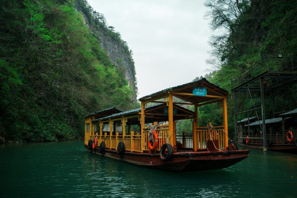 Traditional wooden boat ride in Kilim Karst Geoforest Park Langkawi surrounded by limestone cliffs and mangrove forest